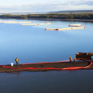 Workers conducting cleanup operations along Garden Island Bay following an oil spill.