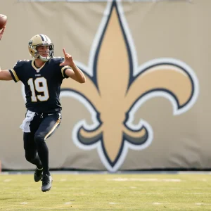 Quarterback on a football field with New Orleans Saints logo