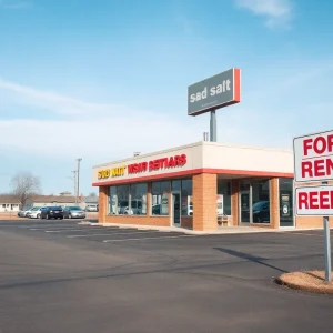 Empty used car dealership lot with a for rent sign